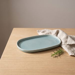 Turquoise ovaal bord 34 x 22 cm van L'AMAR, sfeerfoto 1 op een gedekte tafel